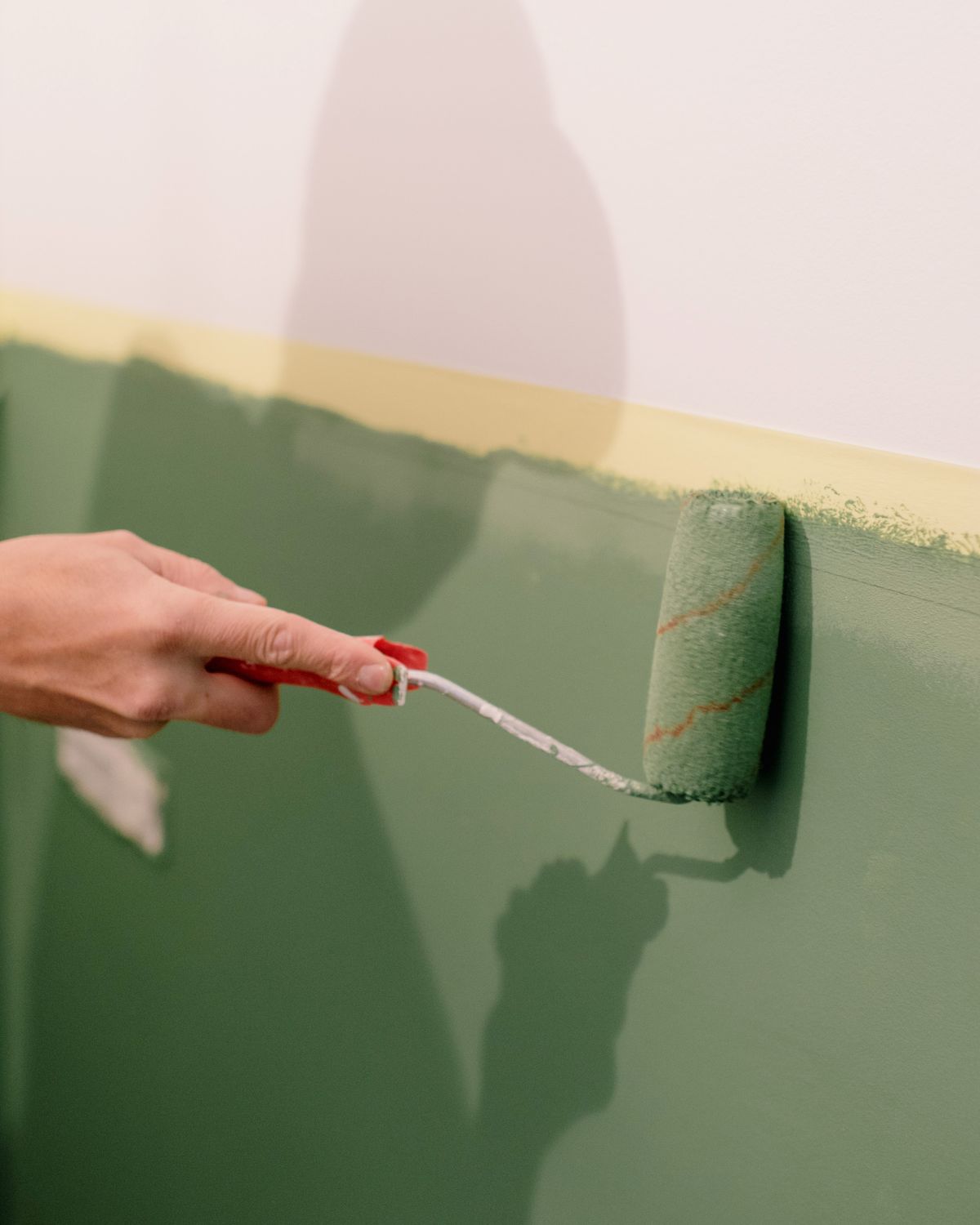 A decorator rolling fresh paint onto a wall, the kind of on-site photo you attach to a quote